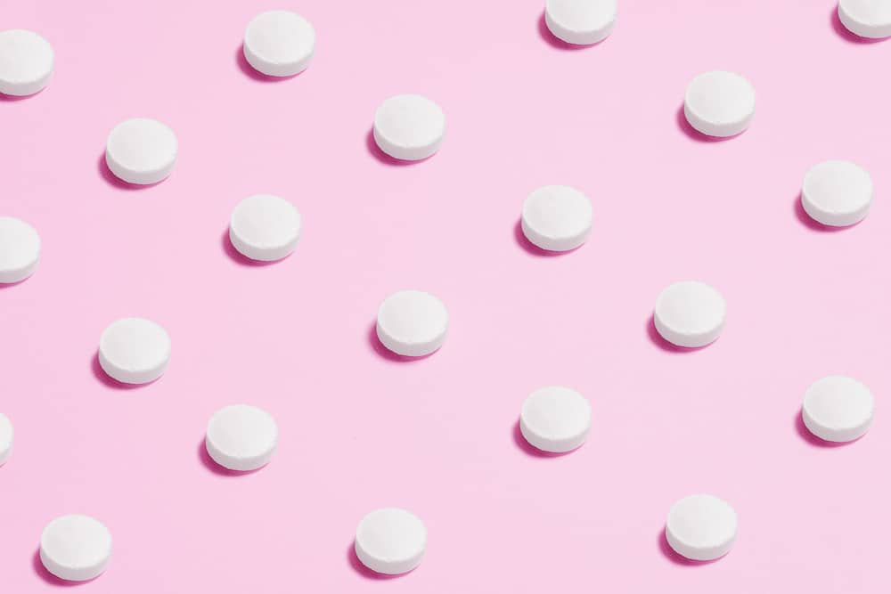 image of tablets with a pink background